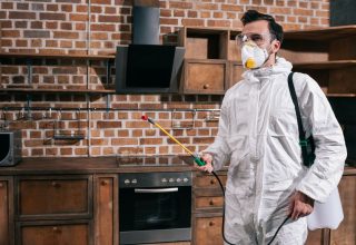 side-view-of-pest-control-worker-standing-with-sprayer-in-kitchen.jpg